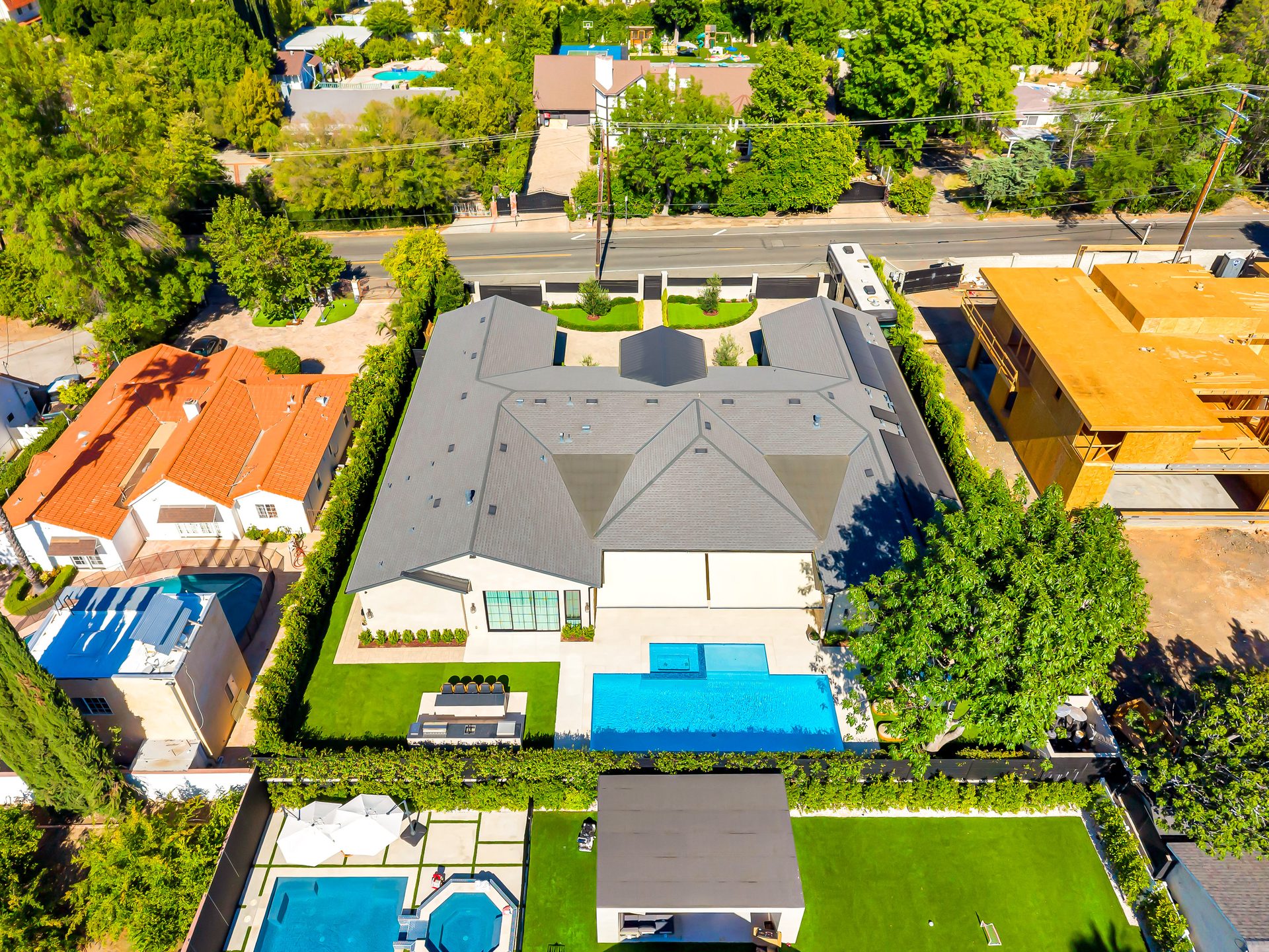 Aerial view of a luxury home with pool and lush lawn