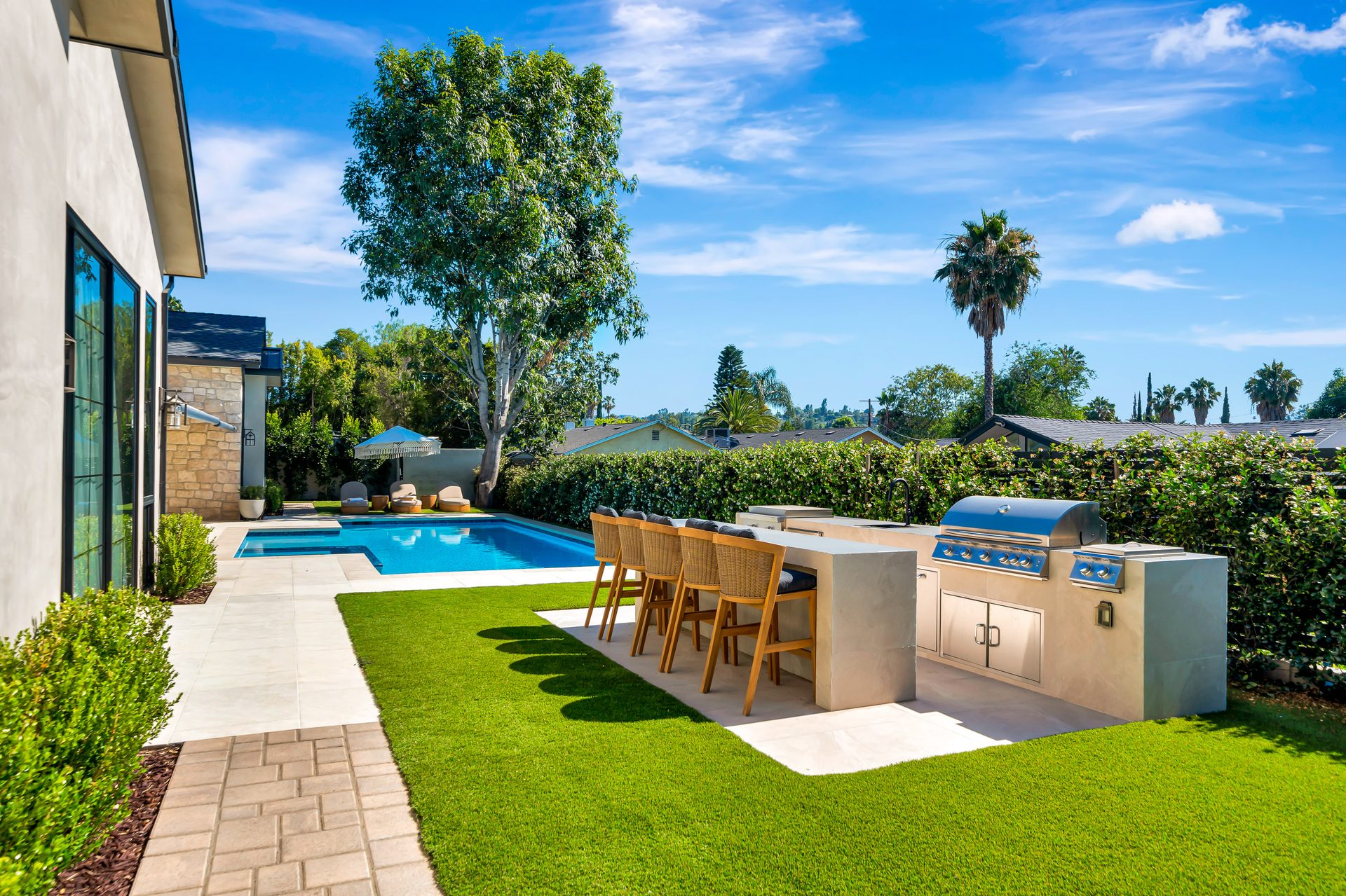 Outdoor kitchen and bar with artificial turf lawn